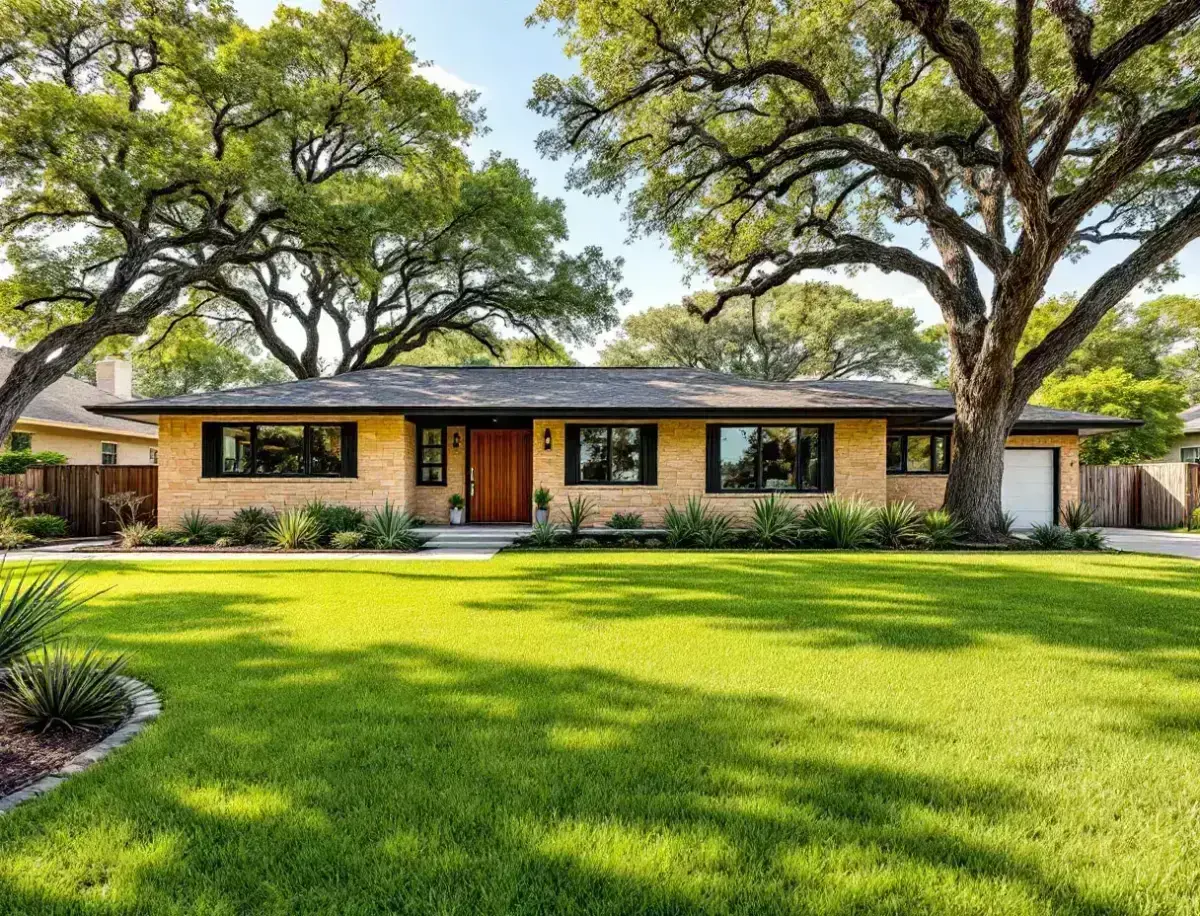 Mid-century ranch home with a low roofline and broad lawn shaded by post oaks on a quiet central Austin street