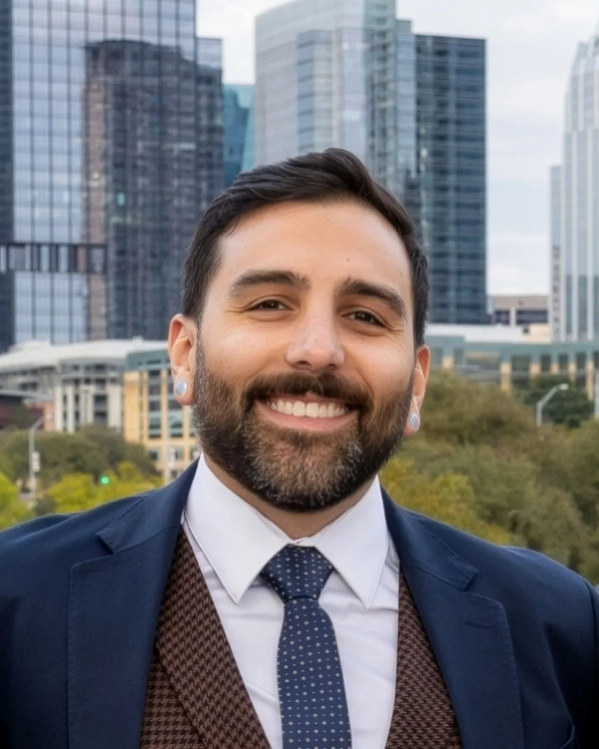Rani Alowairdi, broker-principal of RA Residential, smiling in front of the downtown Austin skyline